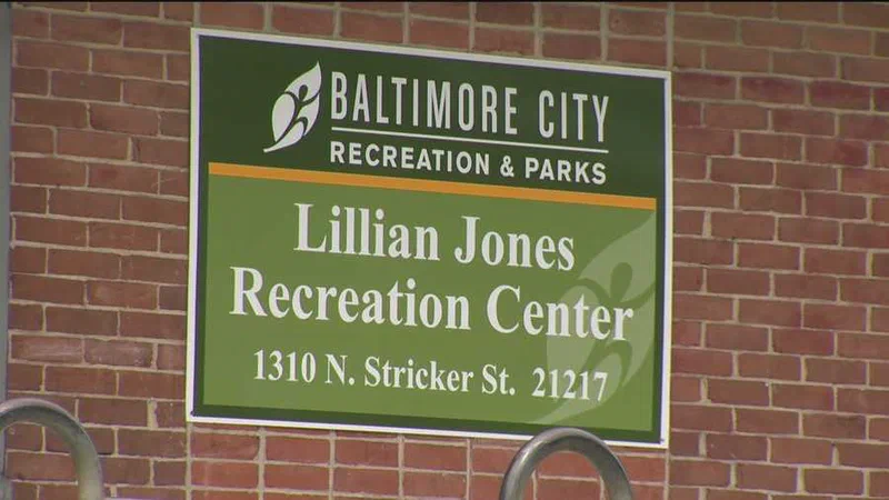 A green and white sign reads 'Baltimore City Recreation & Parks' above 'Lillian Jones Recreation Center,' with the address 1310 N. Stricker St., 21217 displayed below. The sign highlights a potential investment area for American Rescue Plan Act (ARPA) funds to increase spending on community recreation centers.