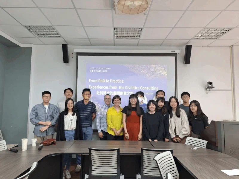 A group of approximately fifteen people, including several women, pose for a photo in a conference room. A presentation on the screen behind them reads 'From PhD to Practice: Experiences from the Civilytics Consulting'. Centered is Jared Knowles and Hannah Miller of Civilytics Consulting.